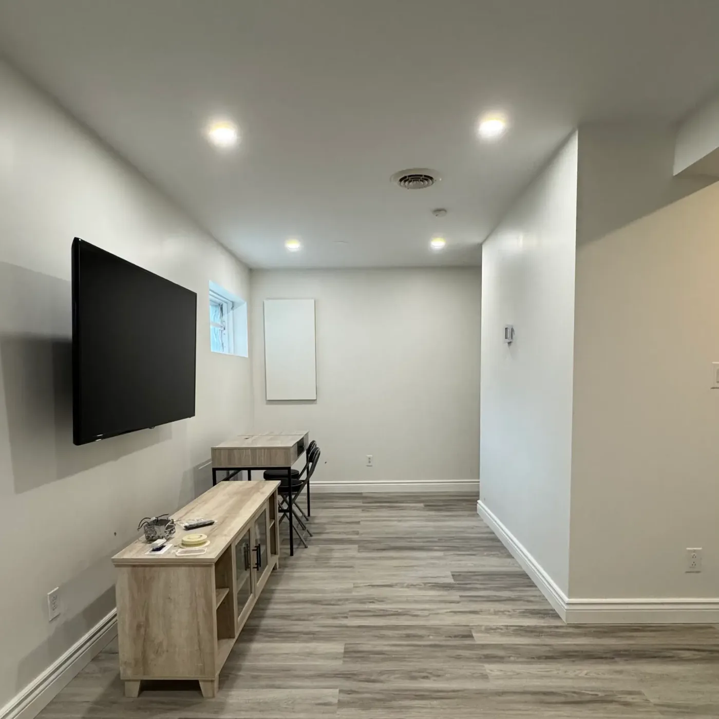Basement den with wall-mounted TV and desk area