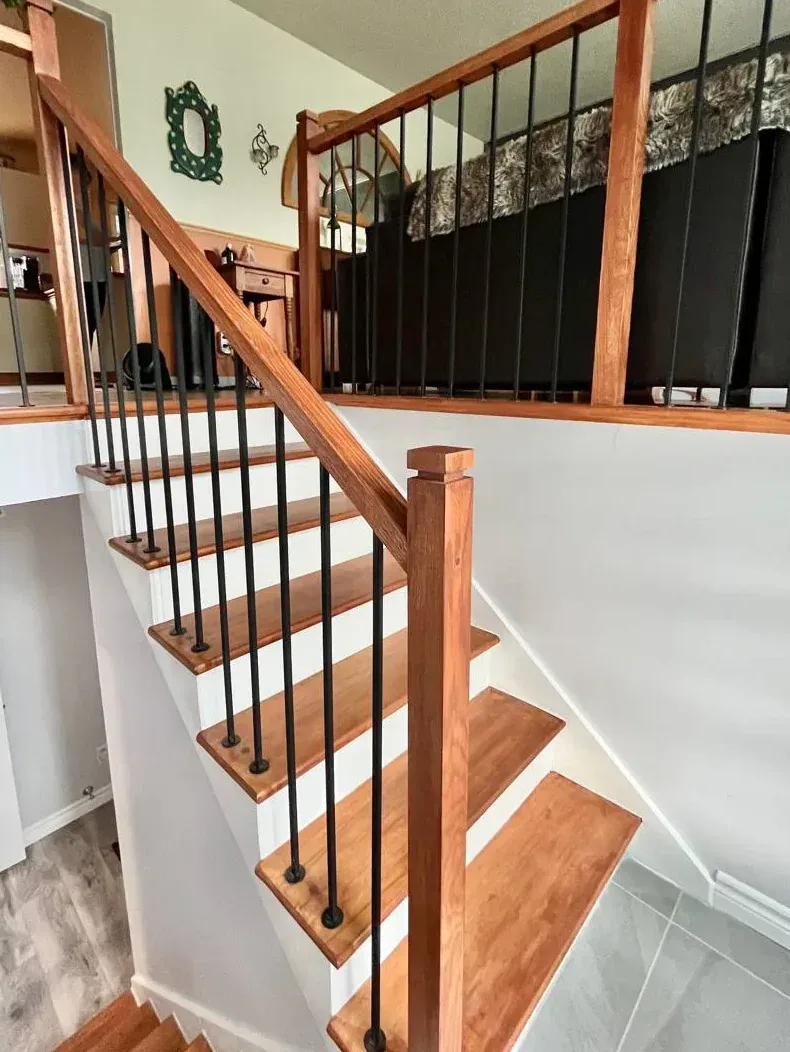 Oak staircase with black iron balusters and square newel post