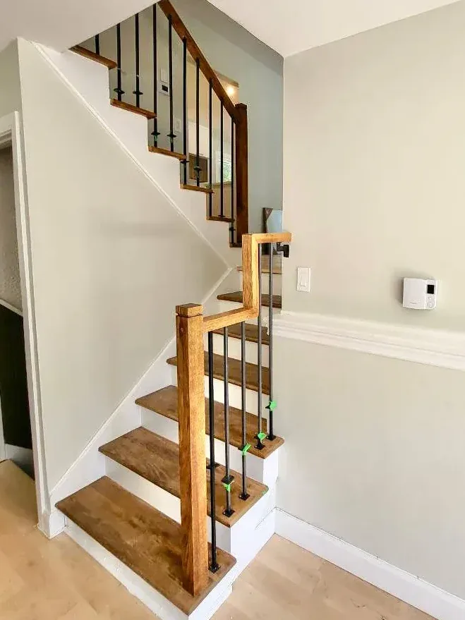 Iron balusters being fitted on an oak staircase during installation