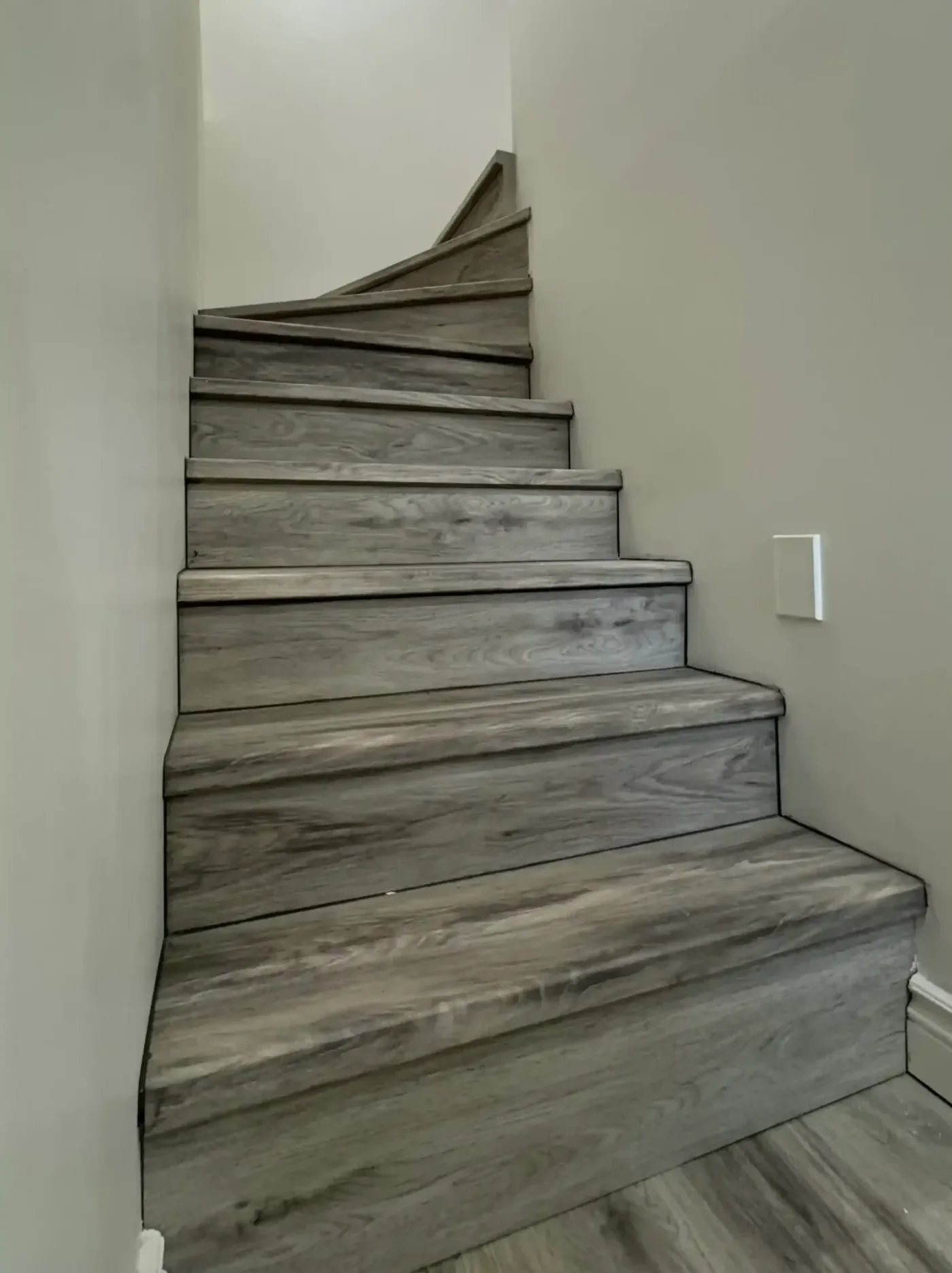 Winder staircase rebuilt with grey vinyl plank treads