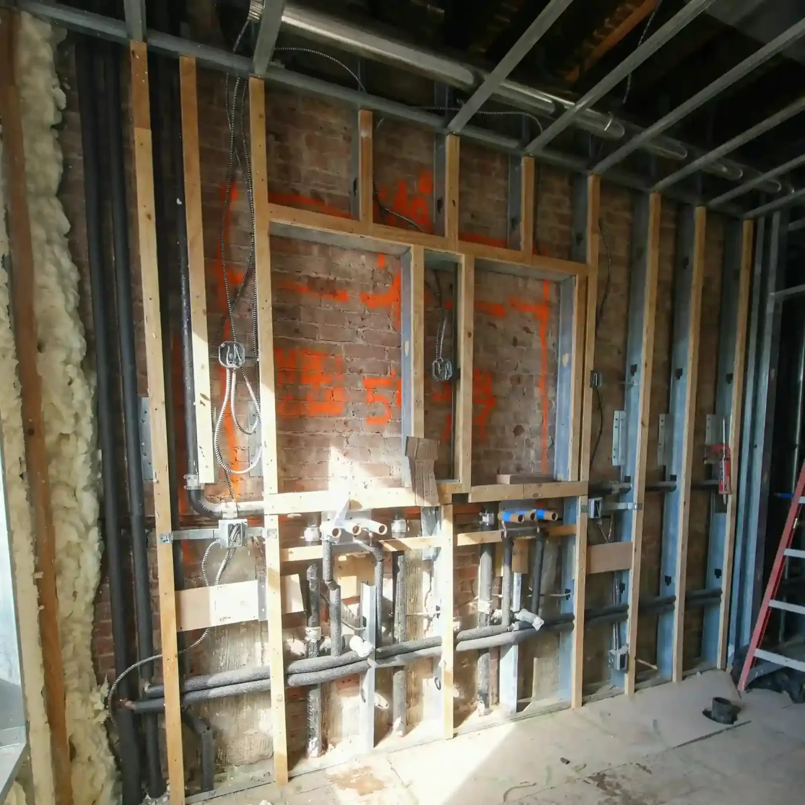 Interior opened to framing with updated plumbing and wiring during a full home renovation