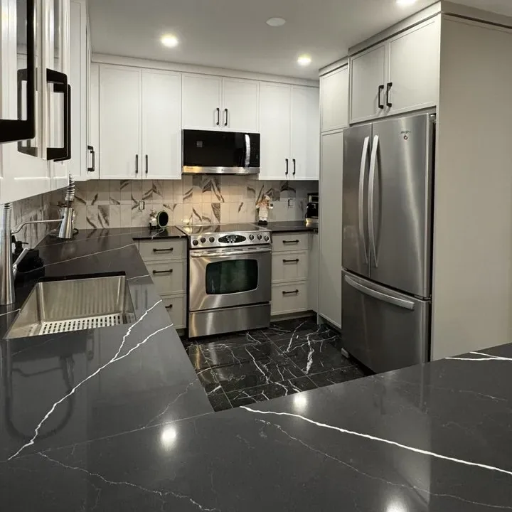Compact kitchen rebuild with black quartz counters and patterned backsplash