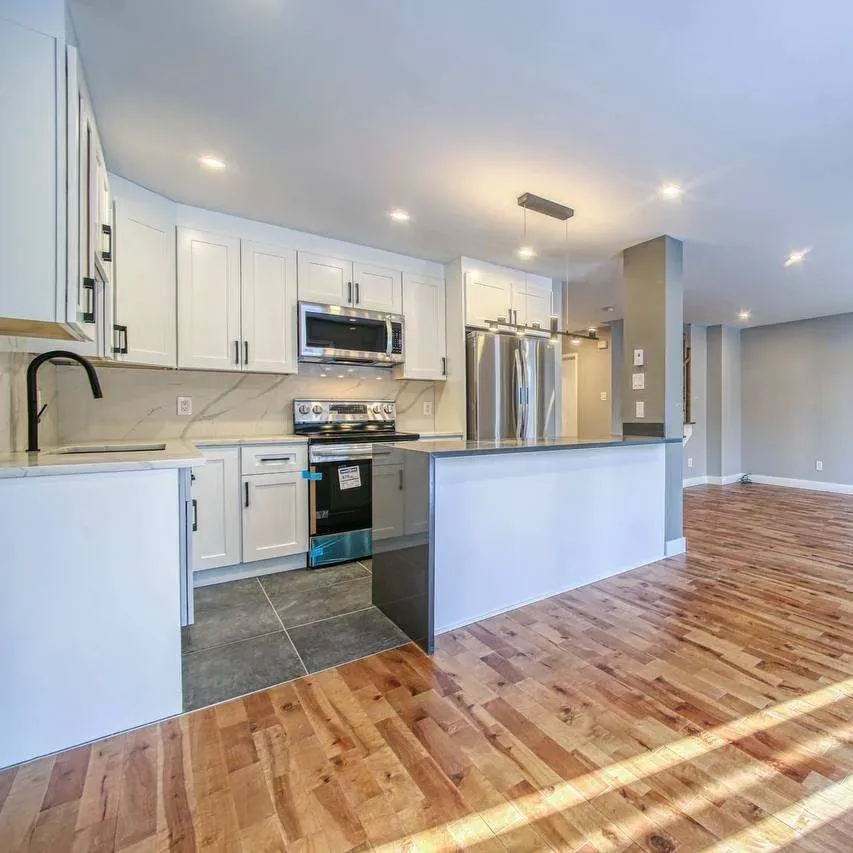 White shaker kitchen with quartz waterfall island